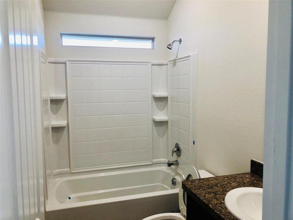 925 Rutherford Drive Crowley, TX 76036 - Photo 12 of 17 a bathroom with a granite countertop bathtub shower sink vanity and toilet