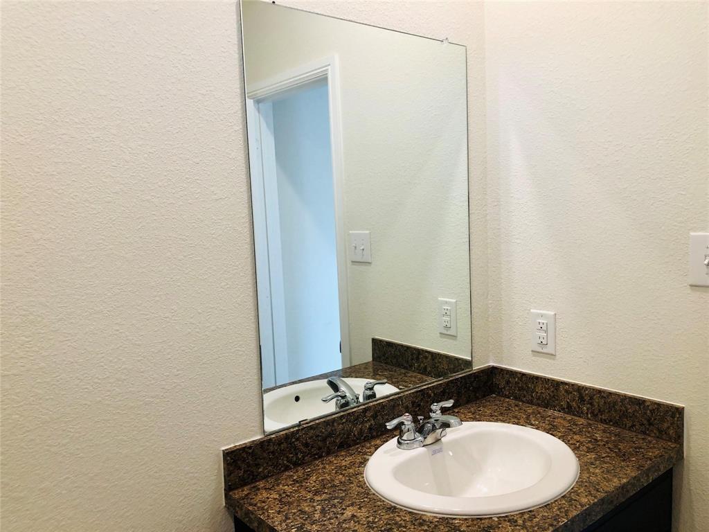 925 Rutherford Drive Crowley, TX 76036 - Photo 13 of 17 a bathroom with a granite countertop sink and a mirror