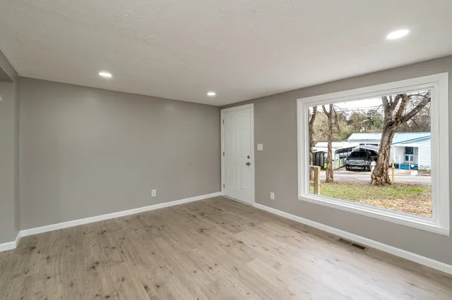 an empty room with wooden floor and a window