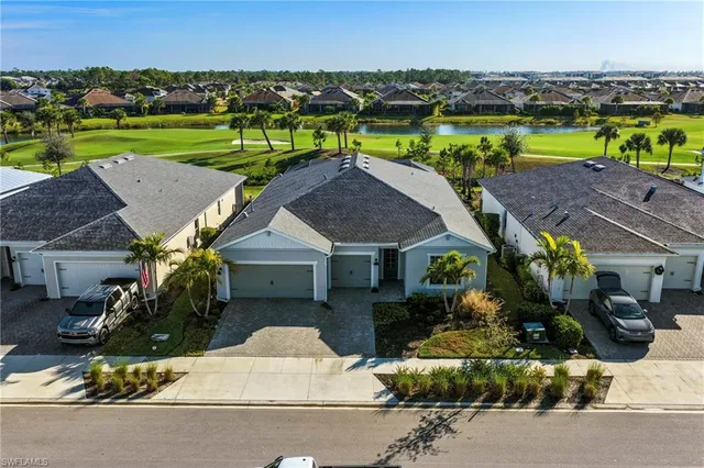 an aerial view of a house with a garden and lake view