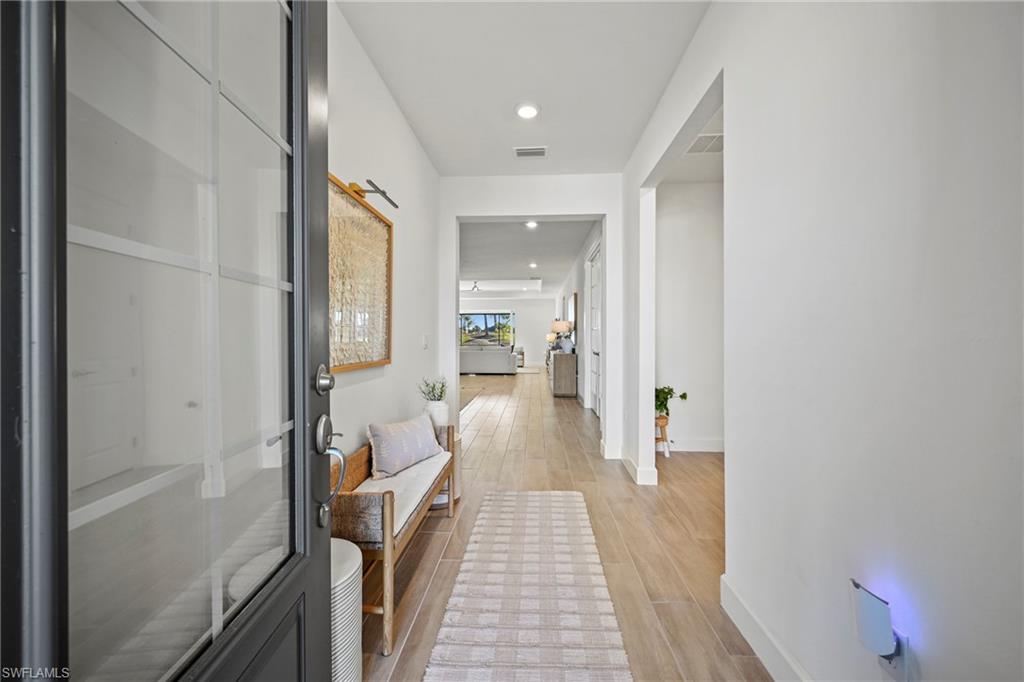 15764 Appalachian Drive Babcock Ranch, FL 33982 - Photo 2 of 46 a view of a hallway with wooden floor and furniture