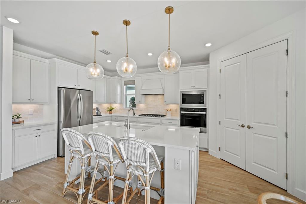 15764 Appalachian Drive Babcock Ranch, FL 33982 - Photo 9 of 46 a open kitchen with stainless steel appliances granite countertop a stove refrigerator and wooden floor