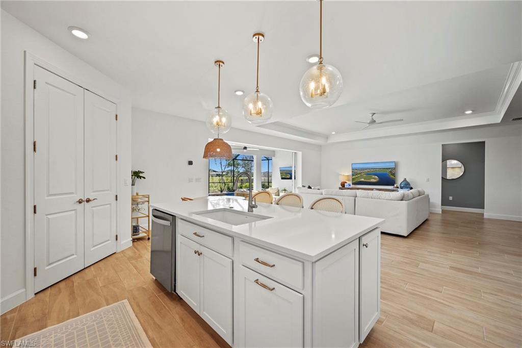 15764 Appalachian Drive Babcock Ranch, FL 33982 - Photo 10 of 46 a kitchen with a sink dishwasher a dining table and chairs with wooden floor