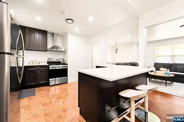 a kitchen with granite countertop a refrigerator stove and sink