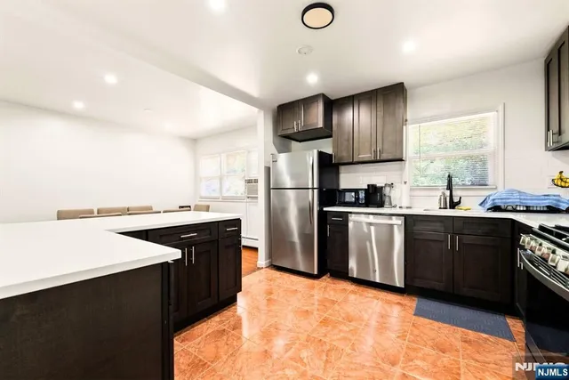 a kitchen with granite countertop wooden cabinets and stainless steel appliances