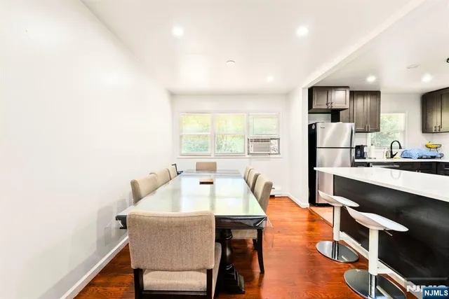 a living room with stainless steel appliances furniture a refrigerator and a view of kitchen