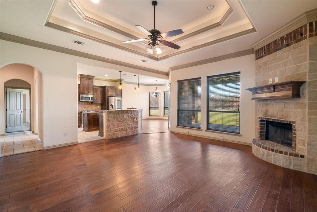 124 Mill Crossing Lane Springtown, TX 76082 - Photo 1 of 1 a view of a livingroom with wooden floor a ceiling fan and windows