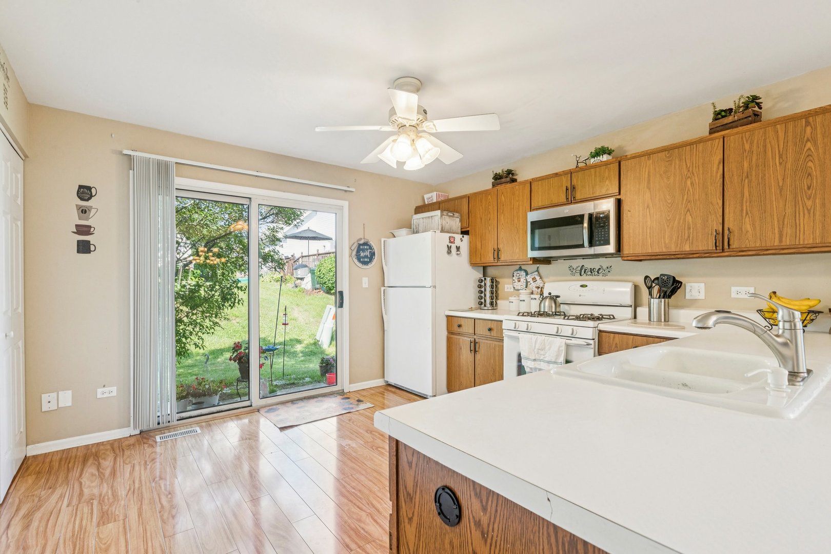 1192 Sumac Trail Hoffman Estates, IL 60192 - Photo 17 of 39 a kitchen with a refrigerator a stove top oven a sink dishwasher and white cabinets with wooden floor
