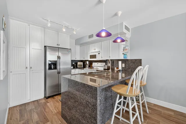 a kitchen with stainless steel appliances granite countertop a sink and a refrigerator