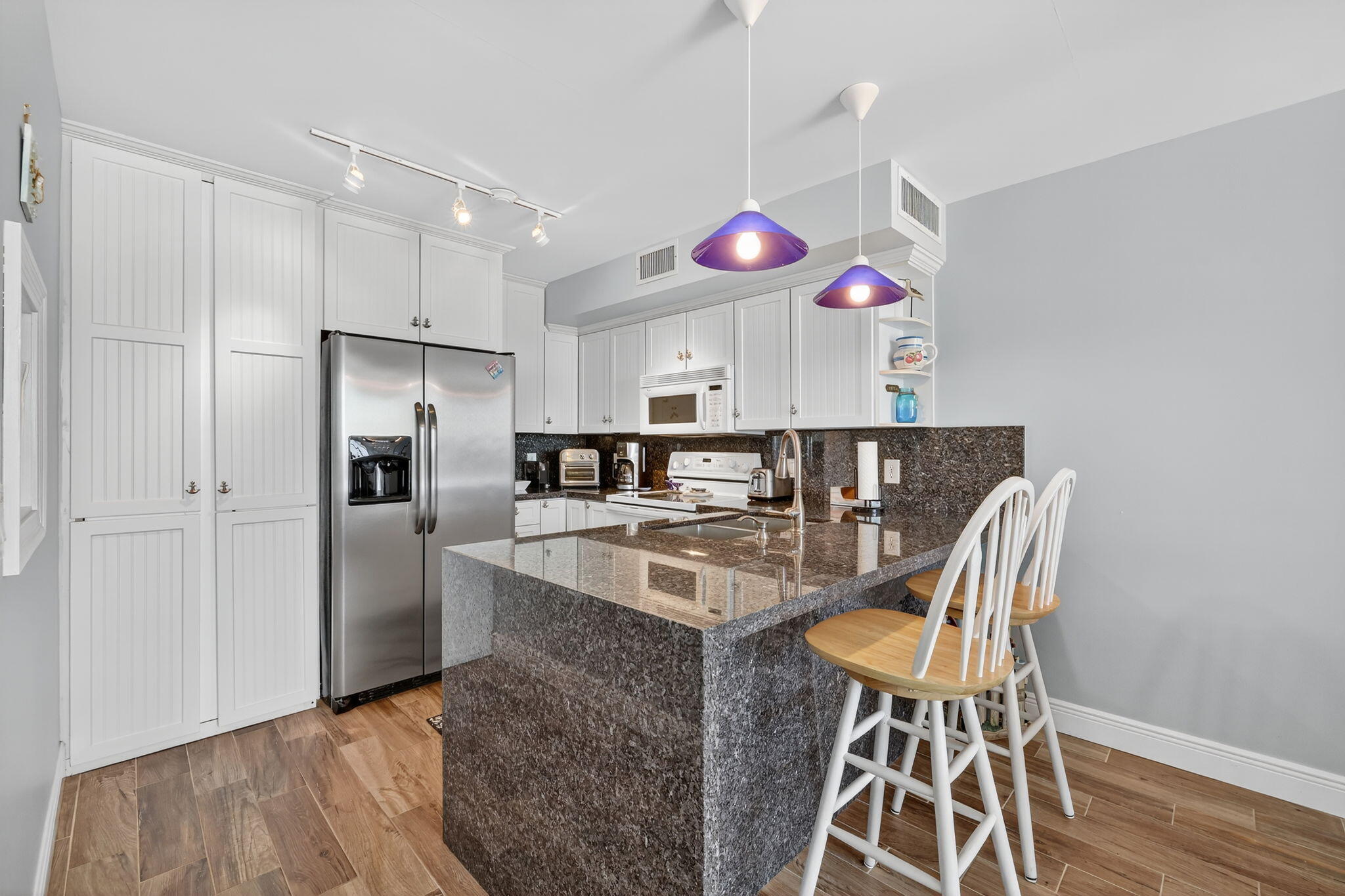 2355 Northeast Ocean Boulevard, Unit 17A Stuart, FL 34996 - Photo 11 of 30 a kitchen with stainless steel appliances granite countertop a sink and a refrigerator