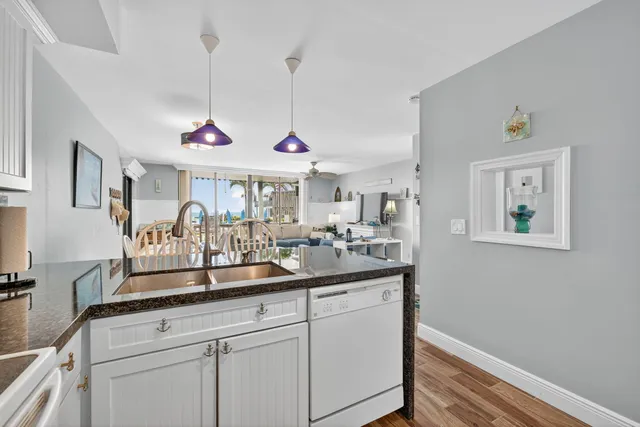 a kitchen with kitchen island white cabinets and sink