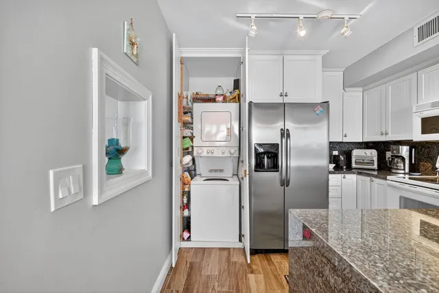 a kitchen with stainless steel appliances granite countertop a refrigerator and a stove top oven