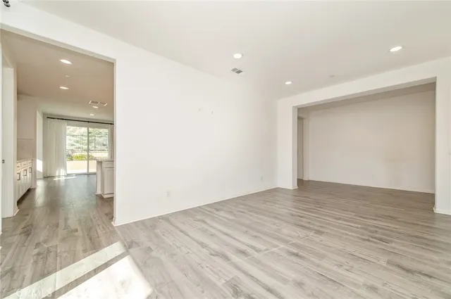 a view of empty room with wooden floor and fireplace