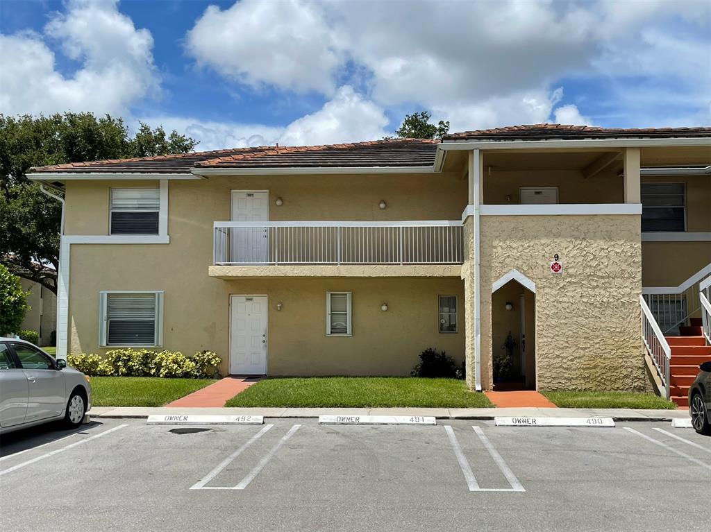 9971 Twin Lakes Drive, Unit 9G Coral Springs, FL 33071 - Photo 1 of 13 a front view of a house with a yard and garage