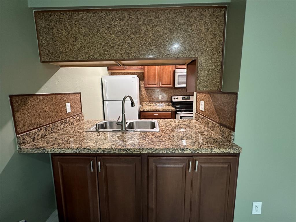 9971 Twin Lakes Drive, Unit 9G Coral Springs, FL 33071 - Photo 11 of 13 a bathroom with a granite countertop sink and a mirror