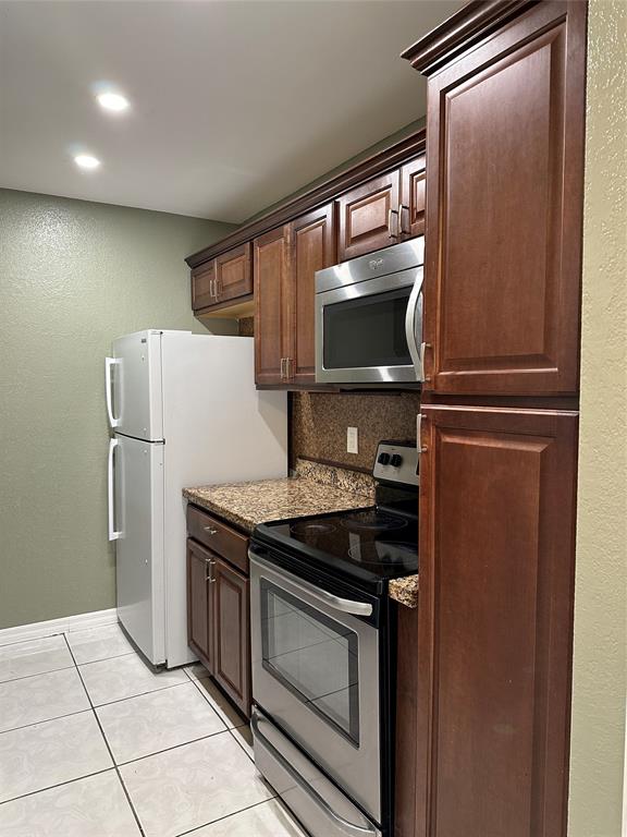 9971 Twin Lakes Drive, Unit 9G Coral Springs, FL 33071 - Photo 3 of 13 a kitchen with a refrigerator and a microwave