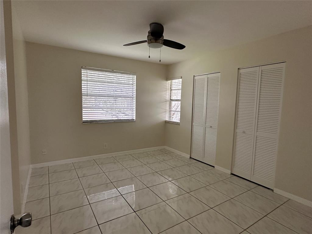 9971 Twin Lakes Drive, Unit 9G Coral Springs, FL 33071 - Photo 9 of 13 a view of an empty room with window and chandelier fan