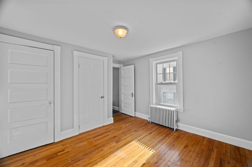 13 Giles Avenue, Unit 2 Beverly, MA 01915 - Photo 8 of 27 a view of an empty room with window and wooden floor