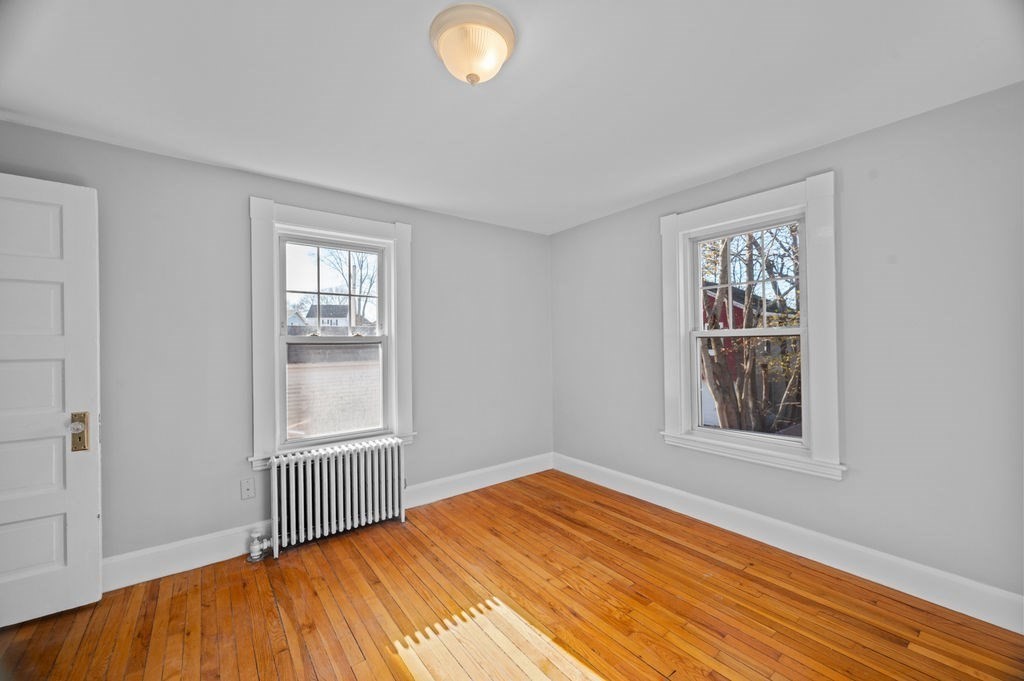 13 Giles Avenue, Unit 2 Beverly, MA 01915 - Photo 9 of 27 a view of an empty room with wooden floor and a window