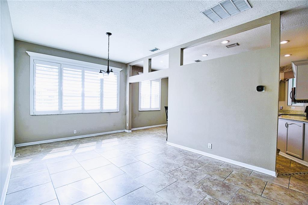 4398 Summertree Road Venice, FL 34293 - Photo 11 of 38 a view of an empty room with window and chandelier fan