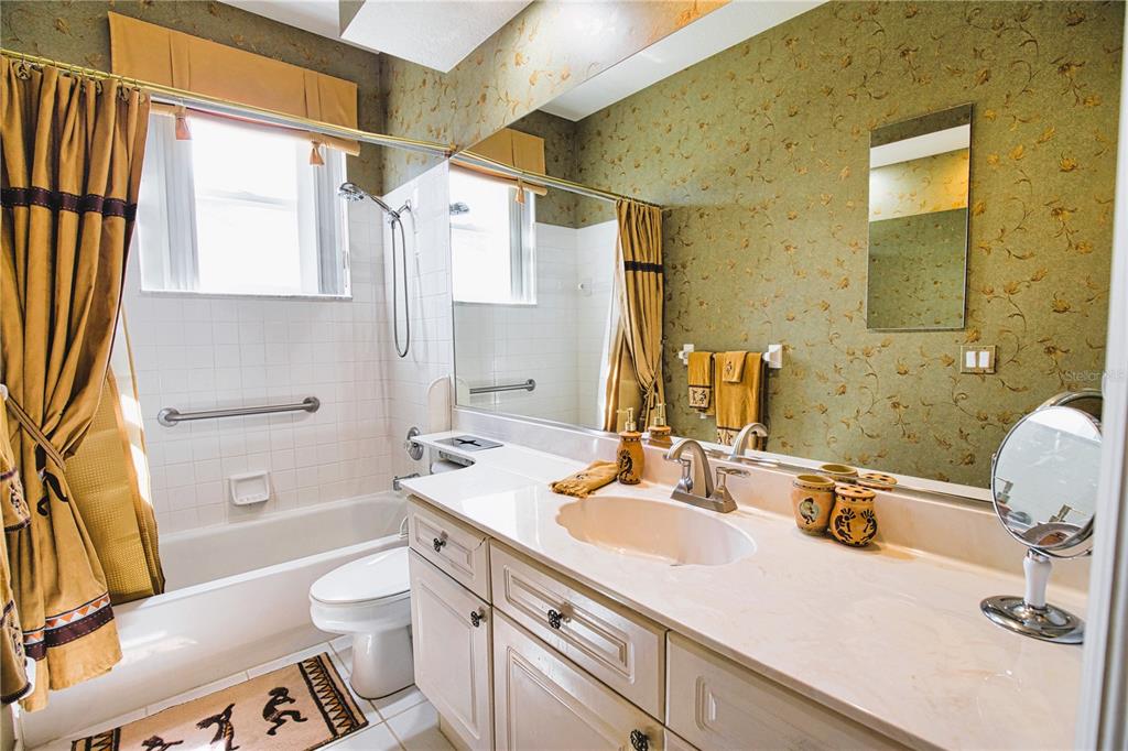 4398 Summertree Road Venice, FL 34293 - Photo 22 of 38 a bathroom with a granite countertop sink toilet and shower