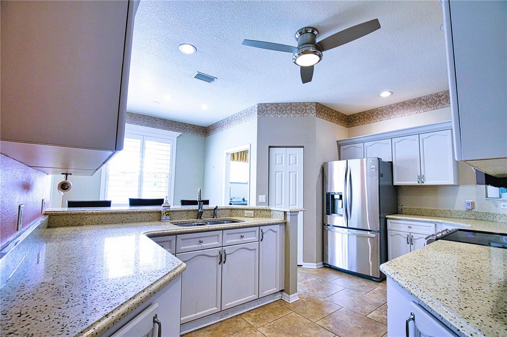 4398 Summertree Road Venice, FL 34293 - Photo 5 of 38 a kitchen with a center island and stainless steel appliances