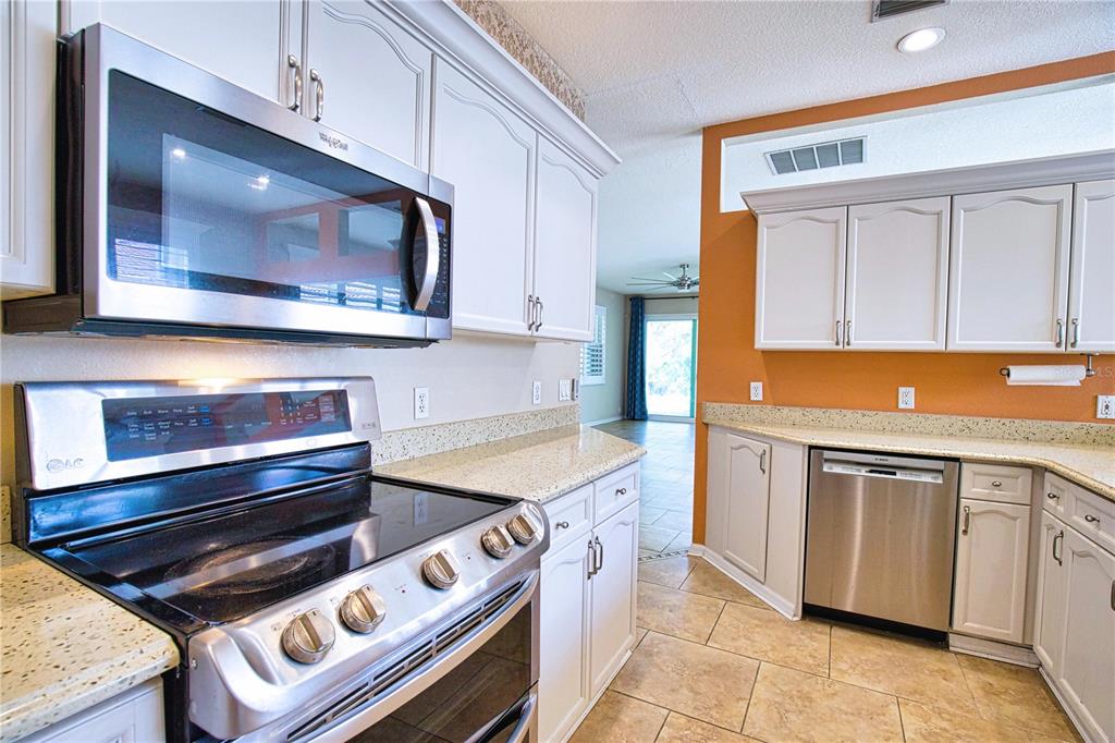 4398 Summertree Road Venice, FL 34293 - Photo 7 of 38 a kitchen with a stove and a microwave