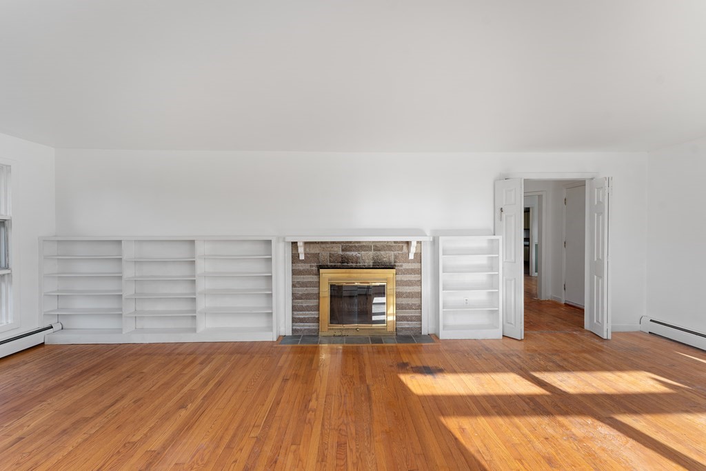 110 Fieldwood Avenue Seekonk, MA 02771 - Photo 17 of 33 an empty room with wooden floor fireplace and windows