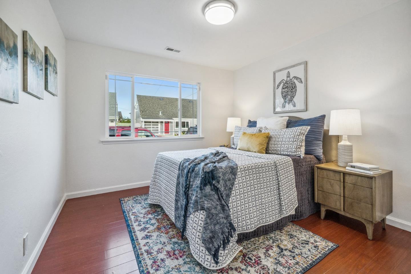 548 Inverness Drive Pacifica, CA 94044 - Photo 11 of 24 a bedroom with a bed and wooden floor