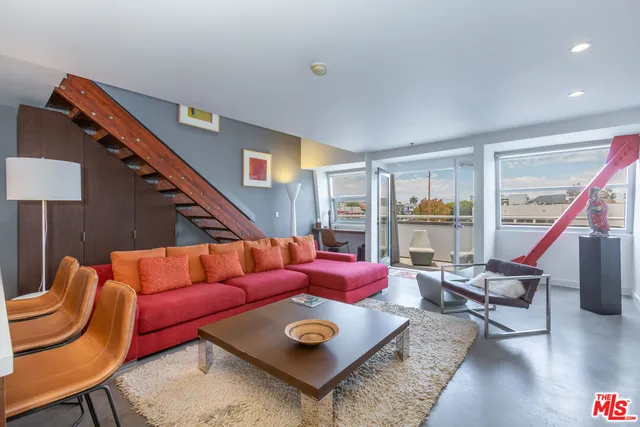 a living room with furniture a rug and a large window