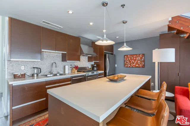 a kitchen with stainless steel appliances a sink stove and refrigerator
