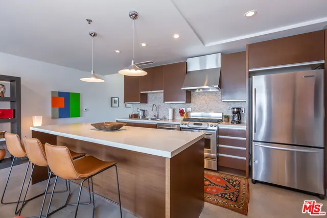 a kitchen with stainless steel appliances granite countertop a sink refrigerator and cabinets