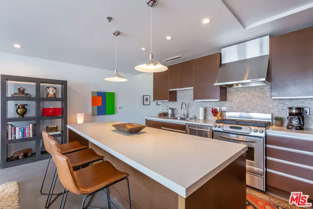 a kitchen with stainless steel appliances a stove a sink dishwasher and cabinets with wooden floor