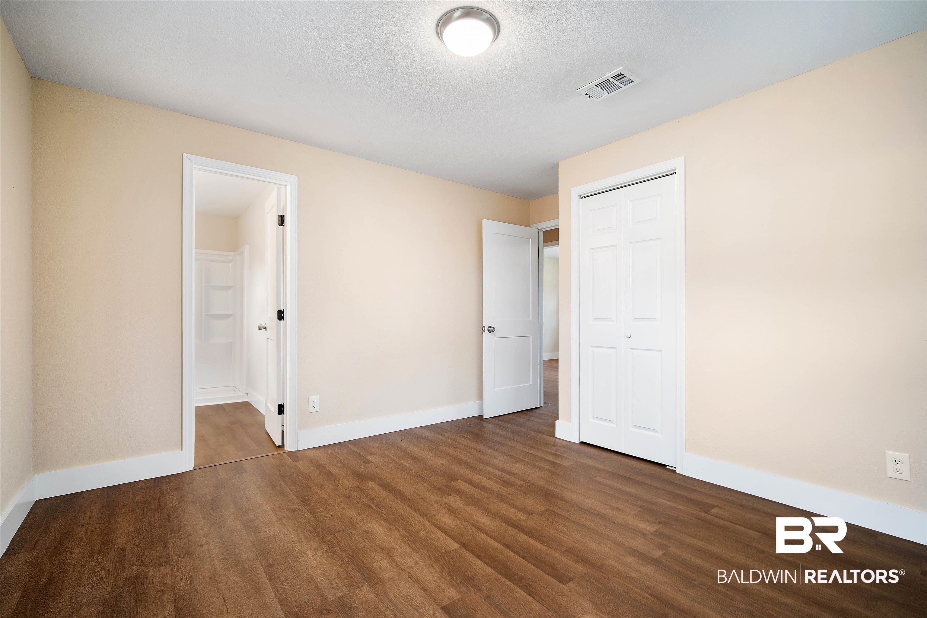 2119 Autrey Avenue Eight Mile, AL 36613 - Photo 12 of 22 Unfurnished bedroom featuring connected bathroom, dark wood-type flooring, and a closet