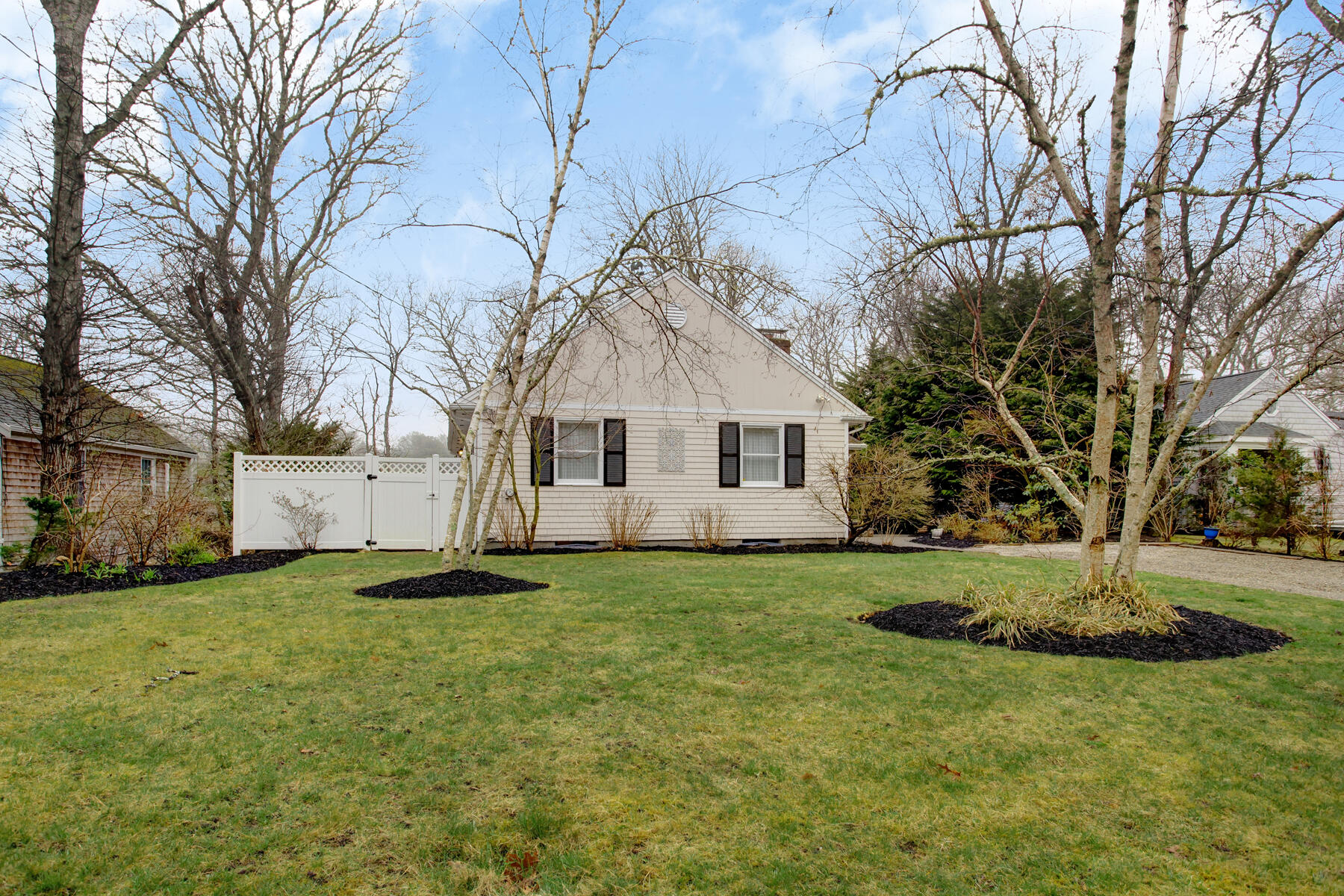 321 Tower Hill Road Osterville, MA 02655 - Photo 4 of 43 a view of a white house next to a yard with a large tree