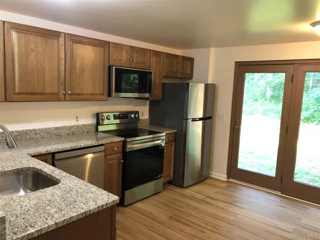 a kitchen with granite countertop a refrigerator and a sink