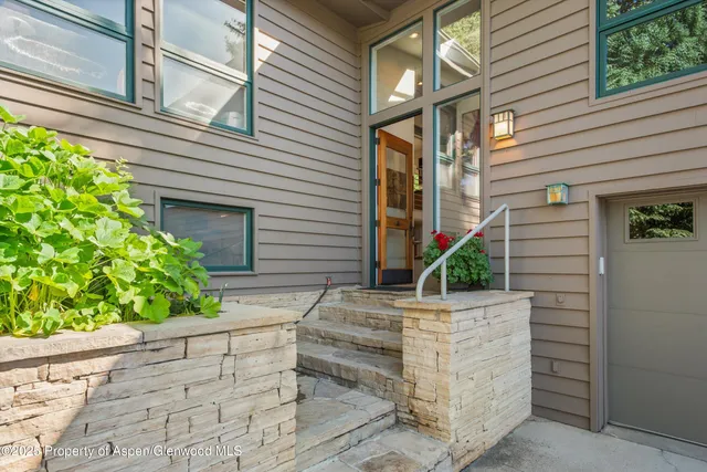 a front view of a house with plants
