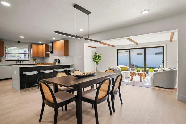 a kitchen with a dining table chairs and refrigerator
