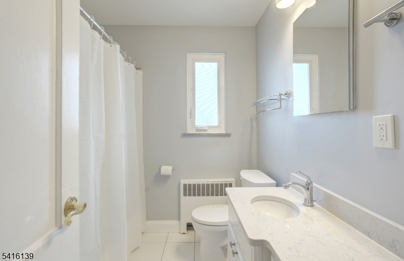 10 Troy Drive, Unit 10A Springfield, NJ 07081 - Photo 16 of 23 a white toilet sitting next to a bathroom sink