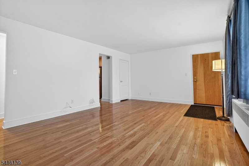10 Troy Drive, Unit 10A Springfield, NJ 07081 - Photo 4 of 23 a view of an empty room with wooden floor and a window