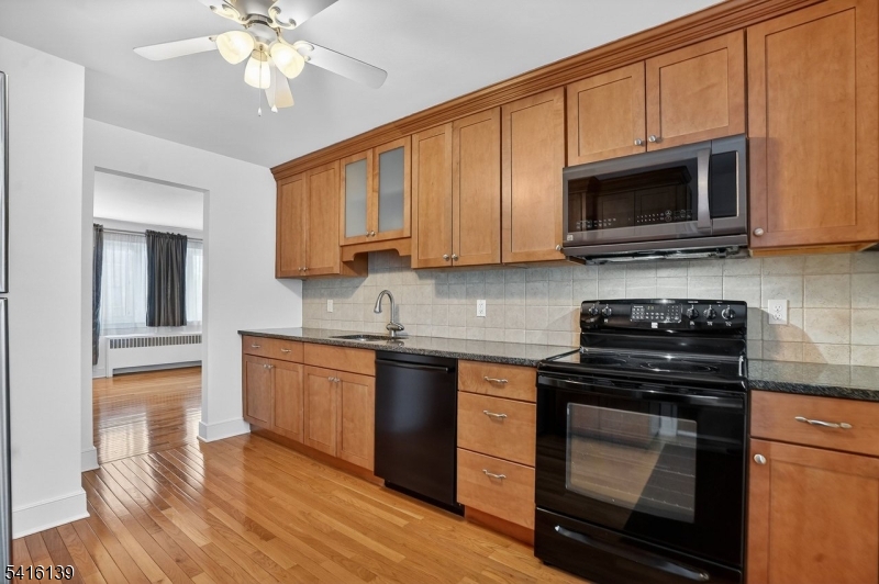 10 Troy Drive, Unit 10A Springfield, NJ 07081 - Photo 7 of 23 a kitchen with stainless steel appliances granite countertop a stove and a microwave