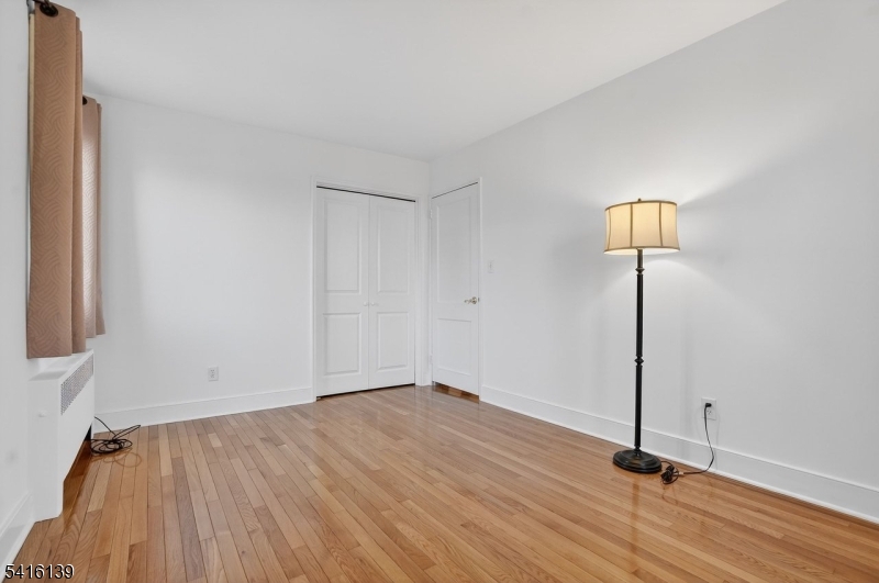 10 Troy Drive, Unit 10A Springfield, NJ 07081 - Photo 10 of 23 a view of a room with wooden floor and a ceiling fan