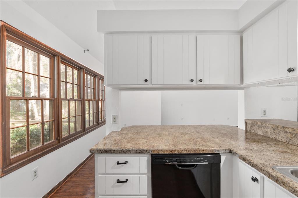 8305 Southwest 46 Lane Gainesville, FL 32608 - Photo 23 of 65 a kitchen with granite countertop white cabinets and a wooden floor