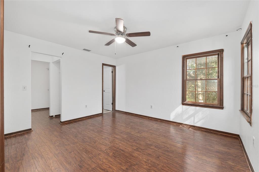 8305 Southwest 46 Lane Gainesville, FL 32608 - Photo 27 of 65 a view of an empty room with wooden floor and a window