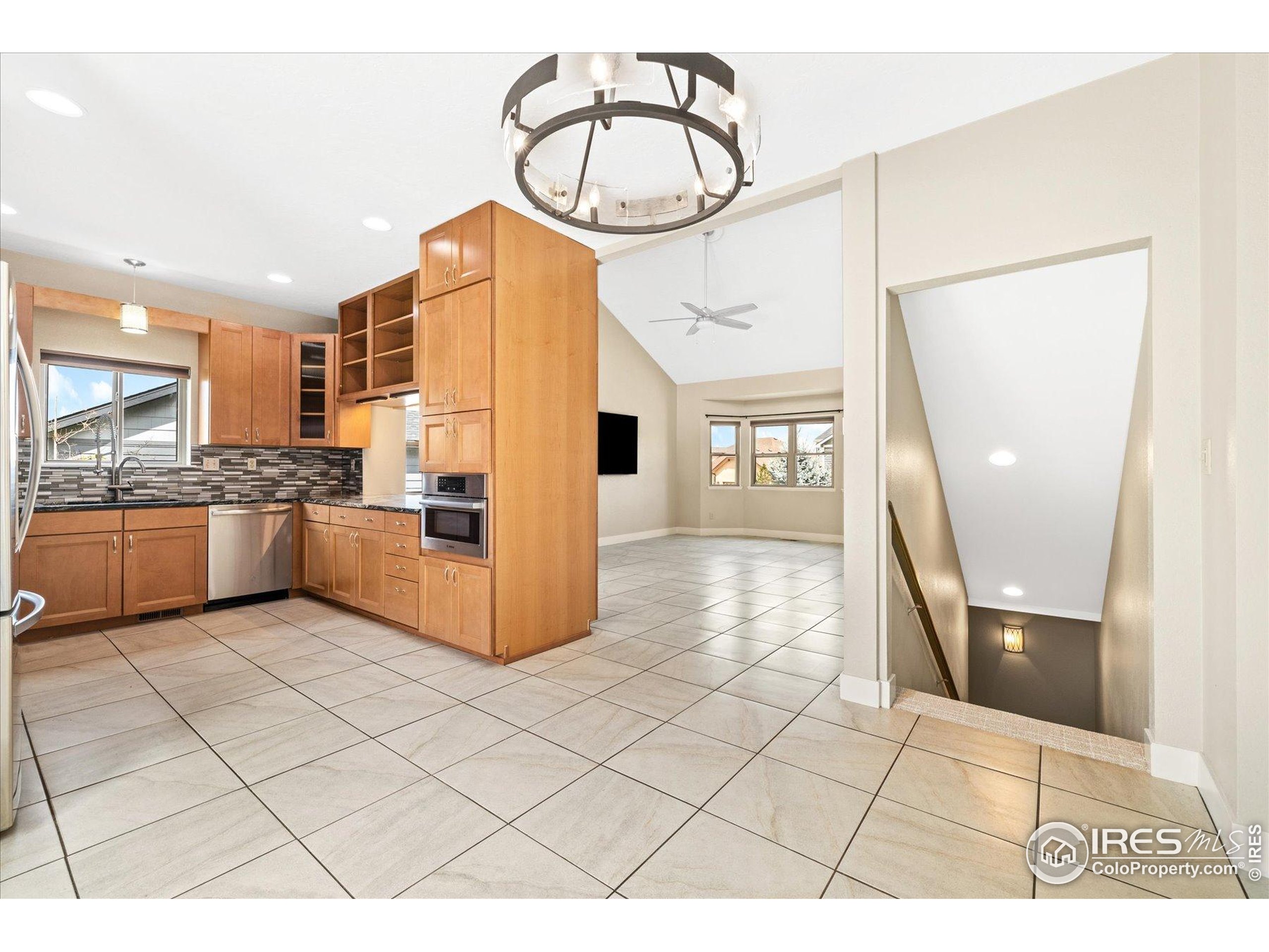 403 Double Tree Drive Greeley, CO 80634 - Photo 12 of 49 a kitchen with granite countertop a refrigerator a stove a microwave and cabinets