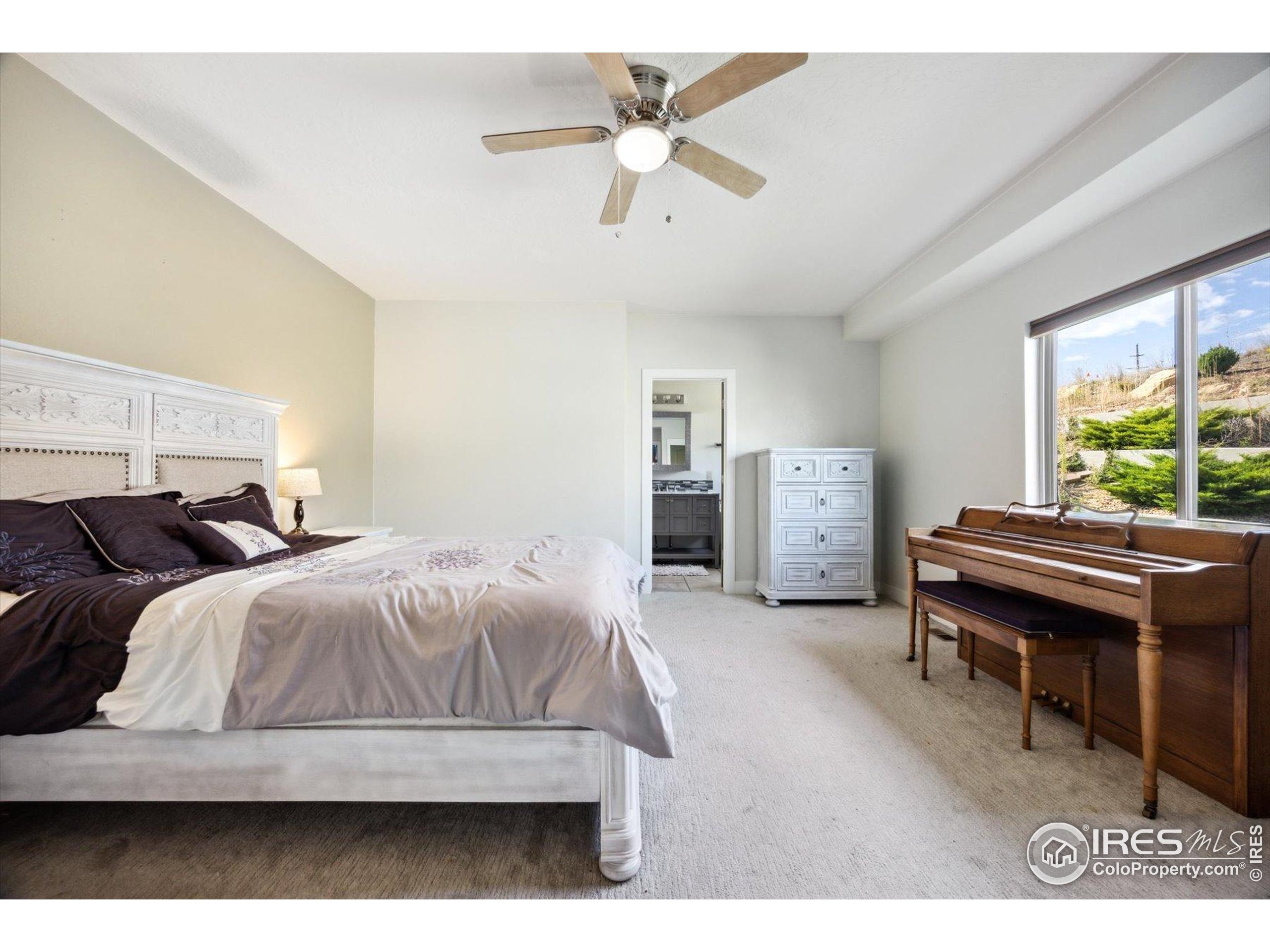 403 Double Tree Drive Greeley, CO 80634 - Photo 15 of 49 a bedroom with a bed and a chandelier