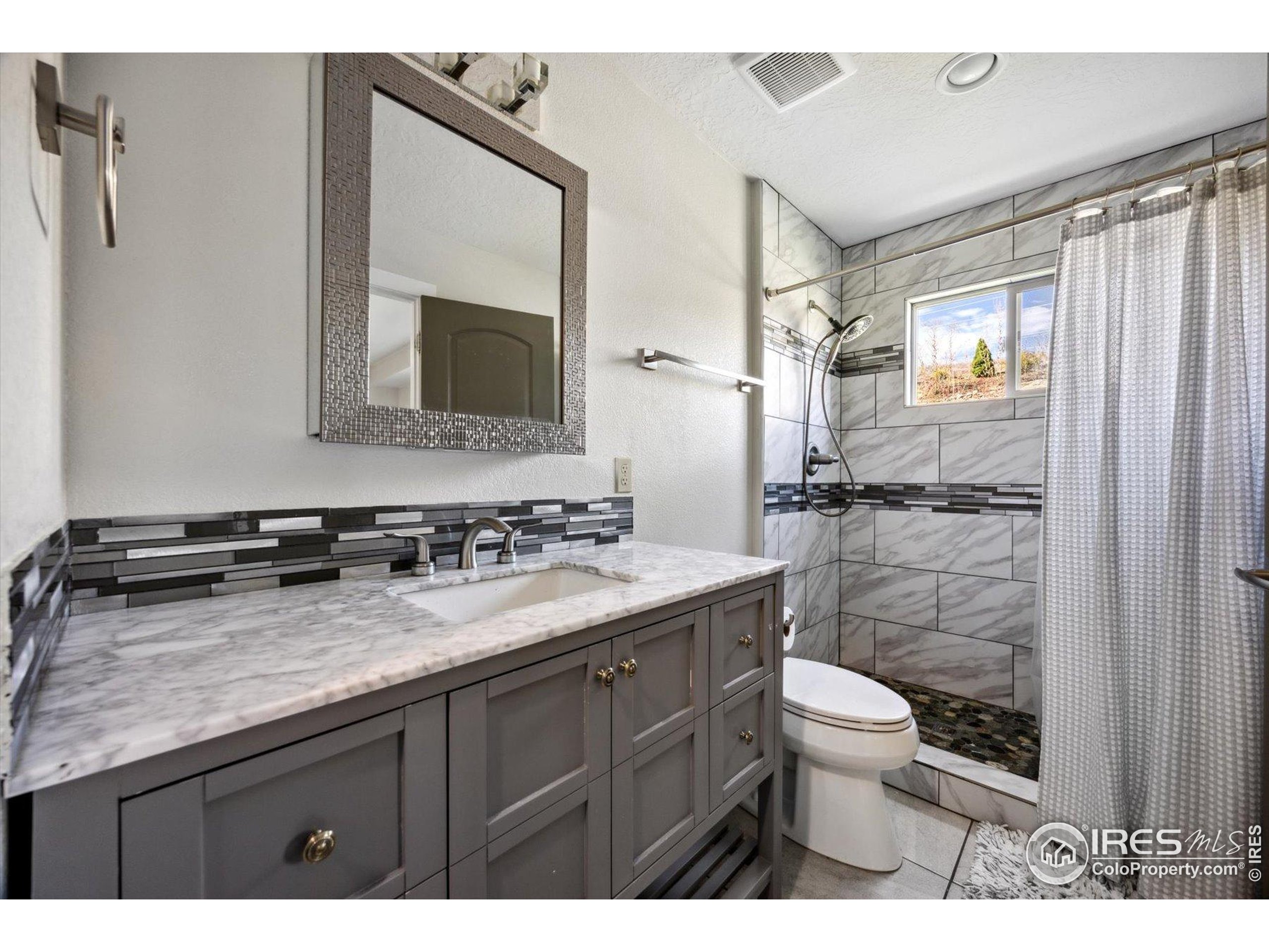 403 Double Tree Drive Greeley, CO 80634 - Photo 17 of 49 a bathroom with a granite countertop sink toilet and shower