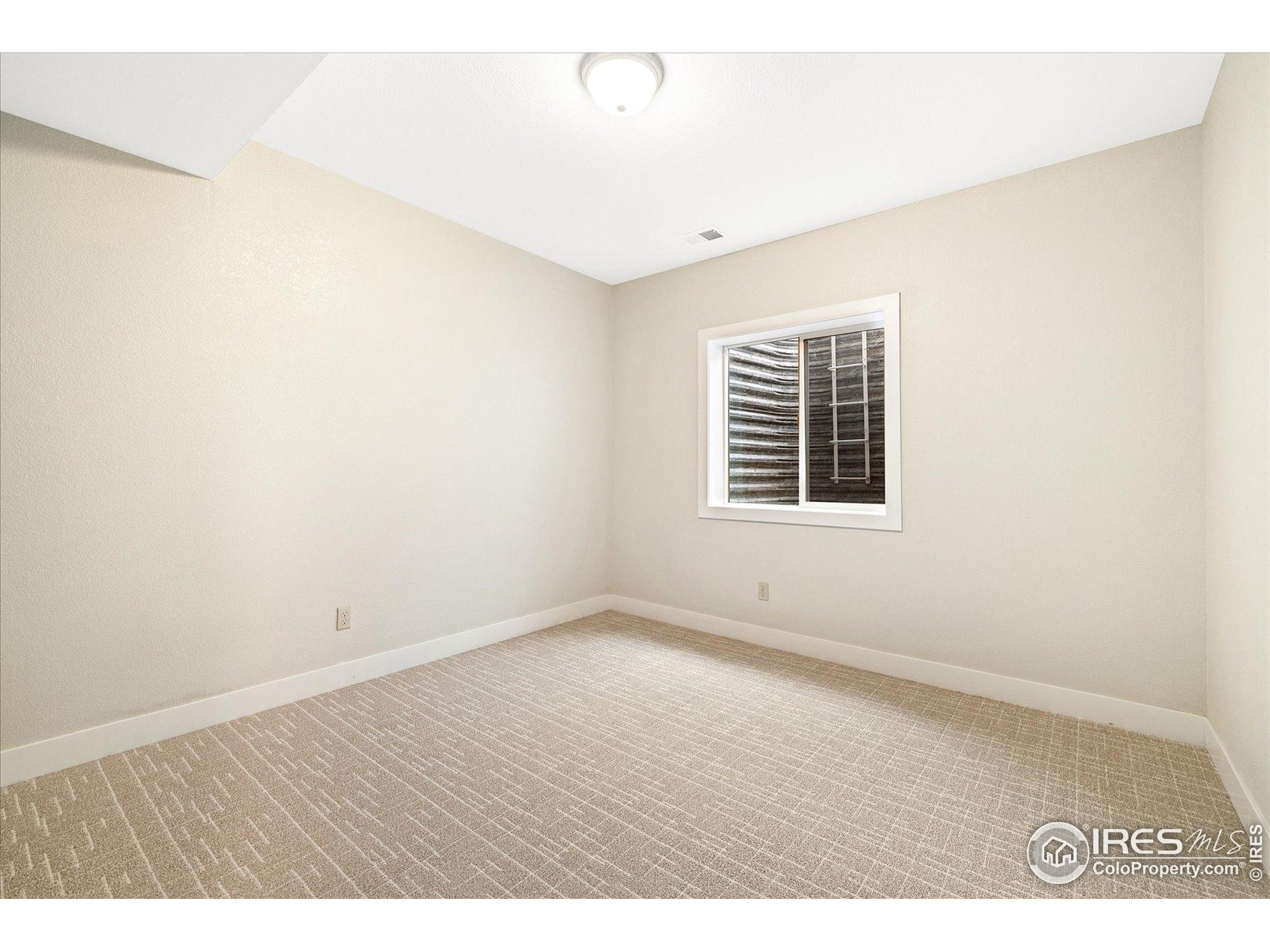 403 Double Tree Drive Greeley, CO 80634 - Photo 36 of 49 an empty room with wooden floor and windows