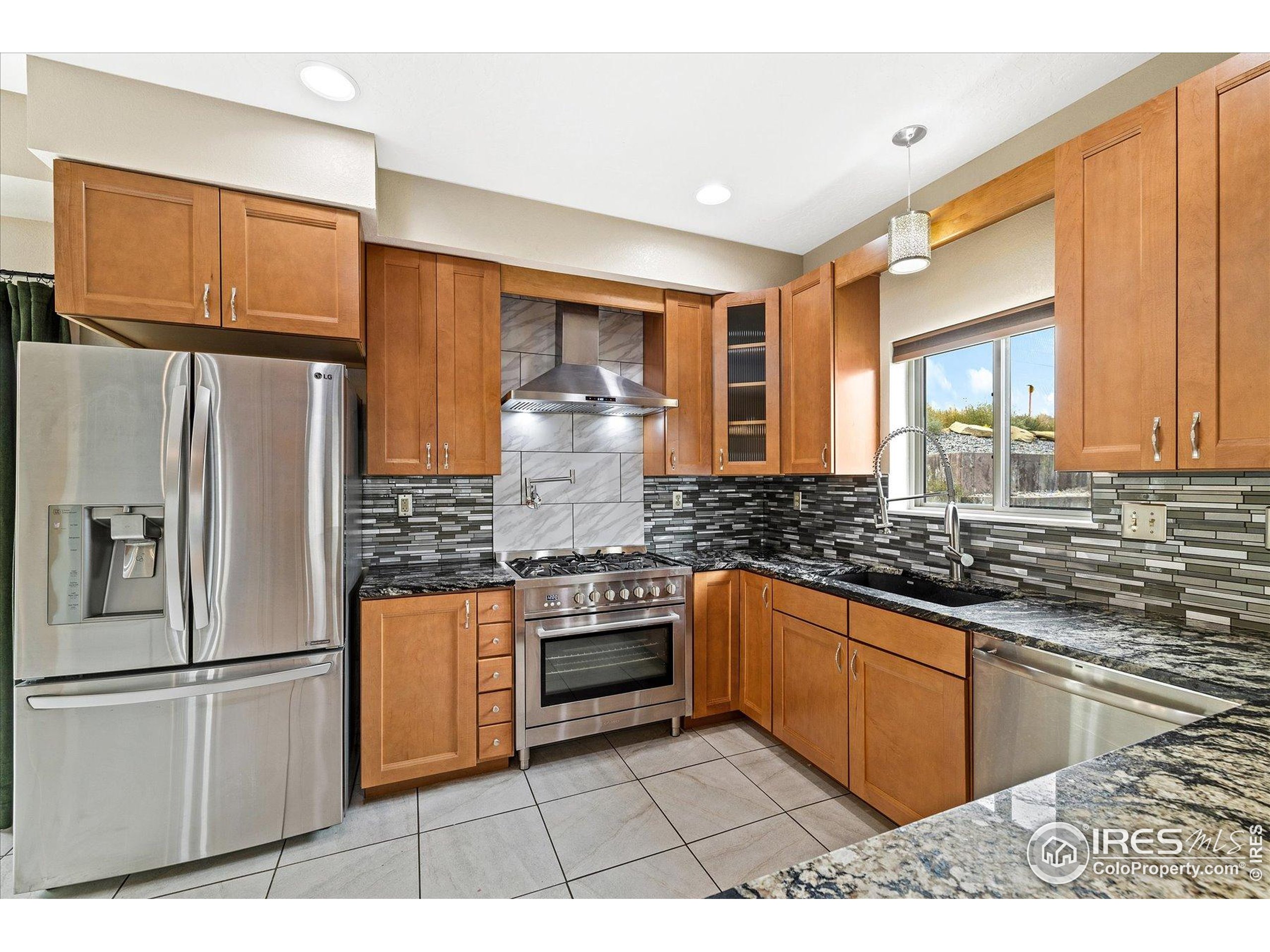 403 Double Tree Drive Greeley, CO 80634 - Photo 9 of 49 a kitchen with stainless steel appliances granite countertop a stove a refrigerator and a sink