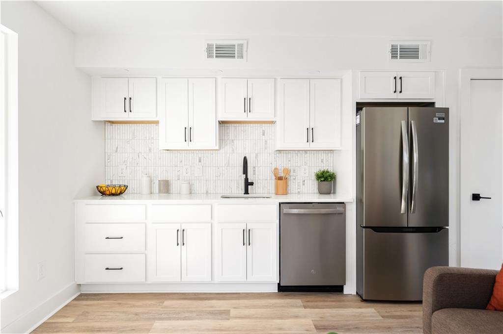 845 Ormewood Terrace Southeast, Unit B Atlanta, GA 30316 - Photo 3 of 32 a kitchen with stainless steel appliances a refrigerator a stove and white cabinets